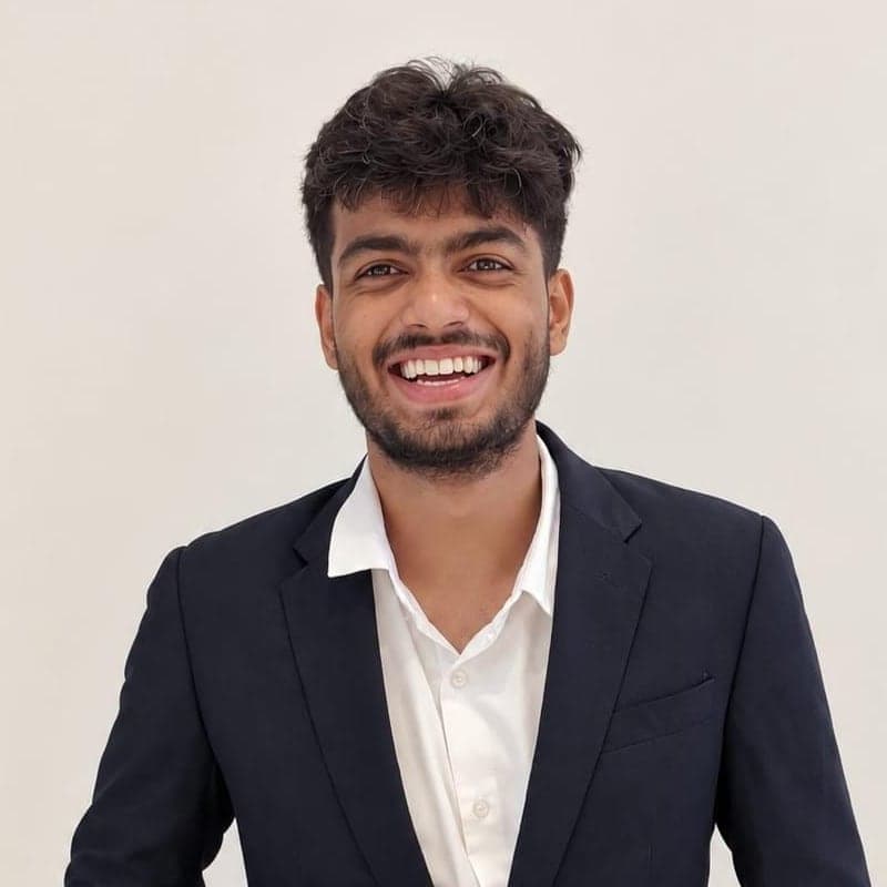 Portrait of Snehansh Yadav, smiling, in a dark blazer and white shirt